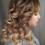 Profile of a woman with styled curly hair.