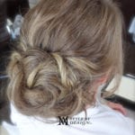 Intricate twisted updo hairstyle on blonde hair.