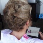 Elegant updo hairstyle on a woman with blonde hair.