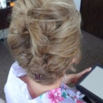 Back view of a woman with a blonde updo hairstyle.