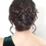 Intricately braided updo hairstyle on a woman with dark hair.