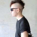Profile of a young man with a mohawk hairstyle and sunglasses.