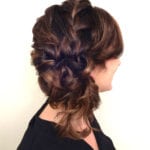 A woman with an intricate braided updo hairstyle.