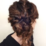 Intricate braided updo hairstyle on brown hair.