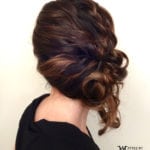 Elegant side bun hairstyle with loose curls and volume.