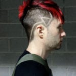 Side profile of a man with red hair and geometric shaved design.