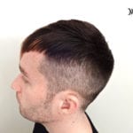 Side profile of a man with a short, faded haircut.