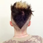 Back view of a person with a heart-shaped haircut and blonde highlights.