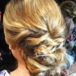Elegant blonde updo hairstyle with intricate twists and curls.