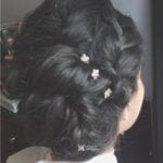 Elegant updo hairstyle with small white flowers.
