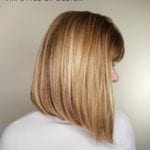 A woman with a sleek, straight bob haircut featuring blonde highlights.