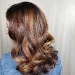 Wavy brunette hair with caramel highlights.