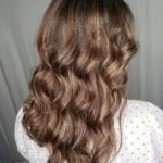 Long wavy brown hair cascading down the back.