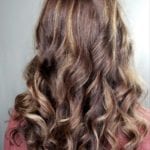Long wavy brown hair with lighter highlights.