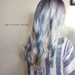 Woman with long, wavy, silver-blue hair styled in loose curls.