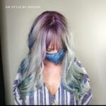 Person with long pastel purple and blue hair wearing a mask.