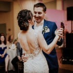 A bride and groom dancing closely at their wedding reception.