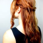 Woman with long, wavy brown hair styled in a half-up braid.