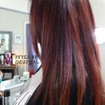 Close-up of long, straight, dark brown hair with subtle red highlights.
