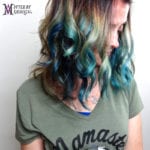 Woman with shoulder-length wavy hair dyed green and blue.