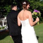 Bride and groom walking outdoors on their wedding day.