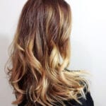 Wavy hairstyle with brown and blonde highlights.