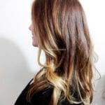 Profile of a woman with long brown and blonde hair.