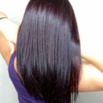 A person with long, smooth, shiny dark hair.