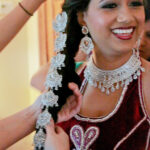 Close-up of a smiling woman wearing traditional jewelry and attire.