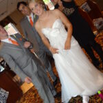 Bride in a white dress and groom in a gray suit at a wedding.