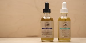 Two dropper bottles with health product labels on a beige background.
