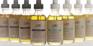 Four bottles of L&M natural oil blends for hair and skin care.