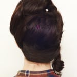 Back view of a person with dark hair styled in a low braid.