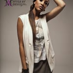 Fashion model wearing a sleeveless white vest and gray blouse posing with arm raised.