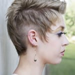Profile of a person with a short, stylish haircut and dangling earring.
