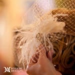 A delicate feather accessory worn in curly hair.