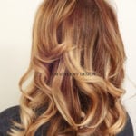 Back view of long, wavy, light brown hair with highlights.