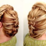 Intricate braided updo hairstyle on blonde hair.