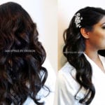 Side and back view of a woman with long, wavy dark hair and a decorative hair accessory.