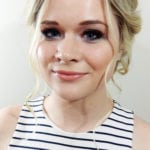 Portrait of a smiling young woman with blonde hair and striped top.