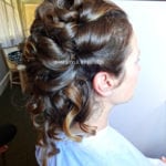 Side view of an elegant braided updo hairstyle with loose curls.