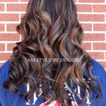 Long wavy brown hair with subtle highlights.