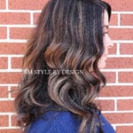 Side view of wavy brunette hair with highlights.