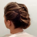 A woman with an elegant braided updo hairstyle.