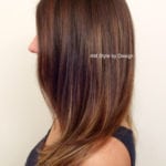 Side view of a woman with smooth, layered brown hair.