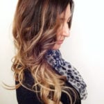 Profile of a woman with long wavy ombre hair and a leopard print scarf.