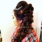 Woman with a detailed braided hairstyle and hair accessories.