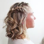 Profile of a woman with curly hair and a braided crown.