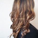 Long wavy brown hair with blonde highlights.