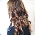 Side view of a woman with long, wavy brown hair.